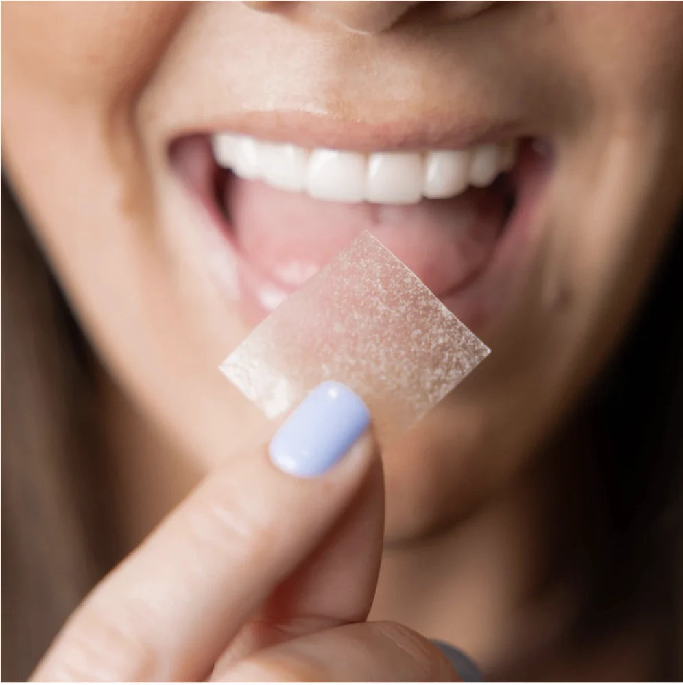Model holding the InstaMed dissolving peptide strip ready for oral use